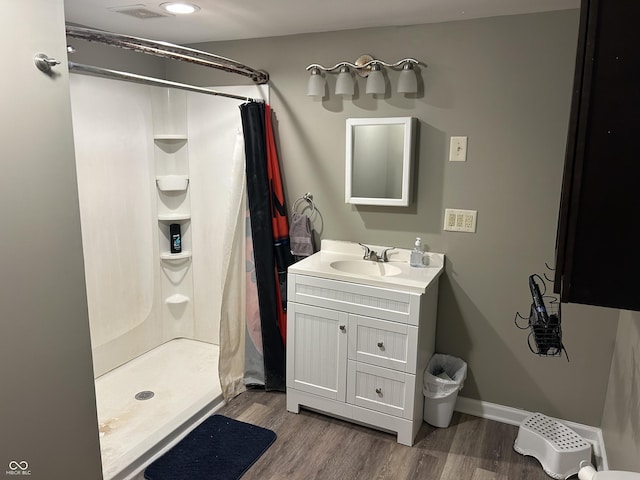 bathroom with wood-type flooring, curtained shower, and vanity