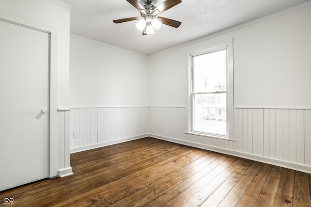 spare room with dark wood-type flooring, ornamental molding, and ceiling fan