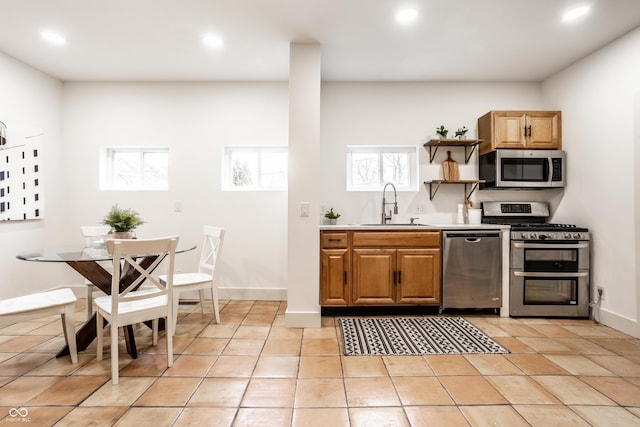 kitchen with light tile patterned flooring, stainless steel appliances, and sink