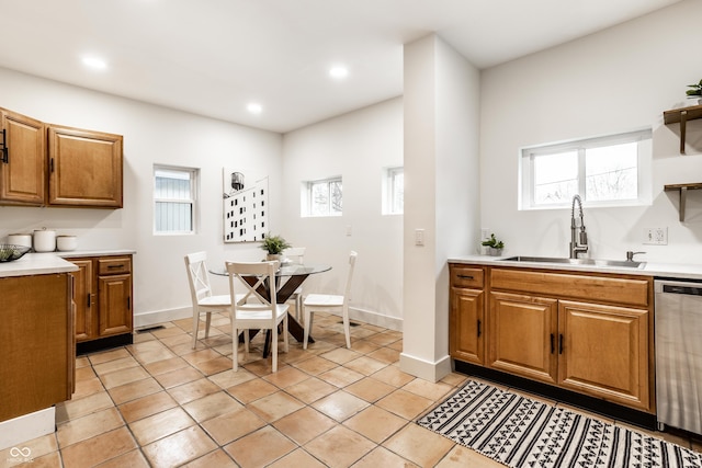 kitchen with light tile patterned flooring, dishwasher, and sink