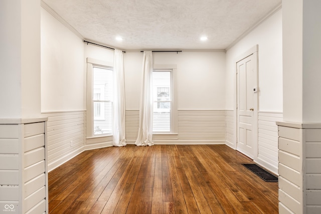 unfurnished room with ornamental molding, dark hardwood / wood-style floors, and a textured ceiling