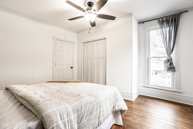 bedroom featuring ceiling fan, ornamental molding, dark hardwood / wood-style floors, and a closet