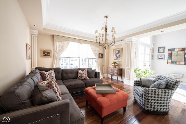 living area with ornamental molding, wood-type flooring, a raised ceiling, and a notable chandelier