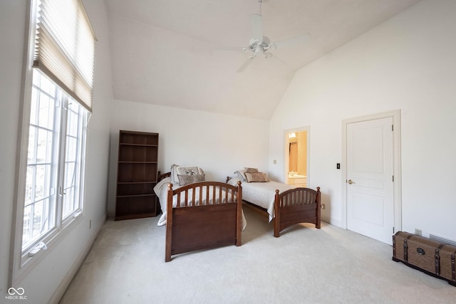 bedroom with baseboards, light colored carpet, ensuite bath, ceiling fan, and high vaulted ceiling