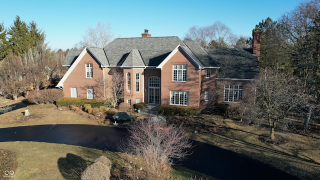 traditional home with brick siding and a chimney