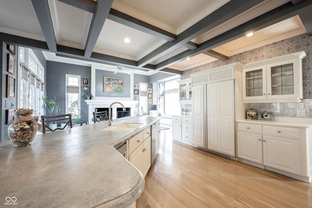 kitchen featuring coffered ceiling, a fireplace, a sink, and beam ceiling