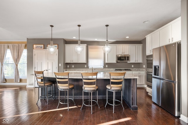 kitchen with white cabinets, appliances with stainless steel finishes, and dark wood-type flooring