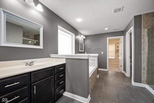 bathroom with visible vents, a walk in closet, a stall shower, tile patterned floors, and vanity