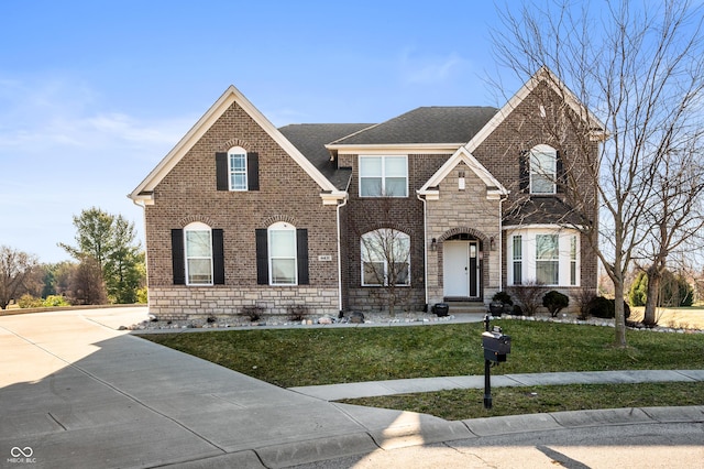 view of front of home with brick siding, stone siding, driveway, and a front lawn