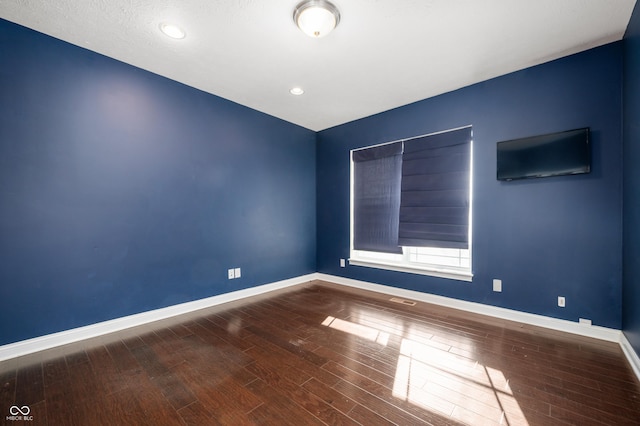 empty room with recessed lighting, visible vents, baseboards, and wood finished floors