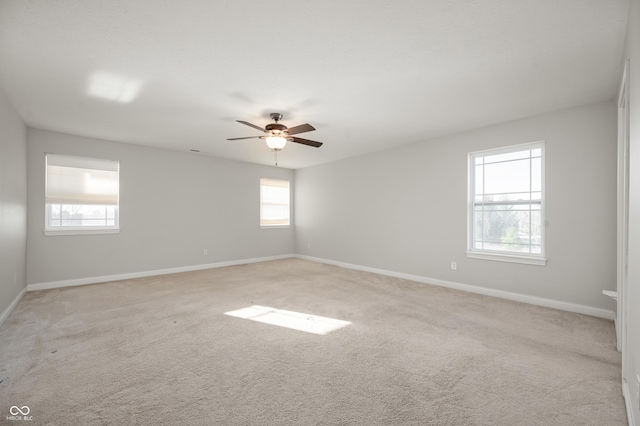 unfurnished room with baseboards, light colored carpet, and a ceiling fan