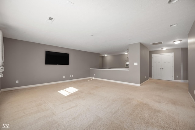 empty room featuring visible vents, baseboards, and light colored carpet