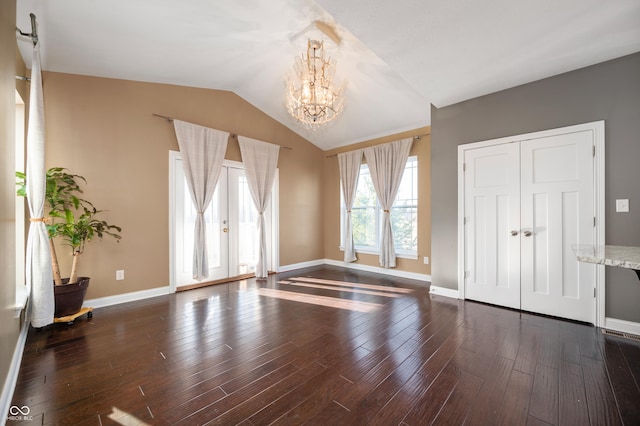 unfurnished room featuring dark wood finished floors, vaulted ceiling, baseboards, and a chandelier