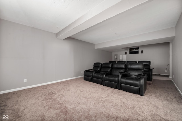 carpeted cinema featuring beam ceiling and baseboards