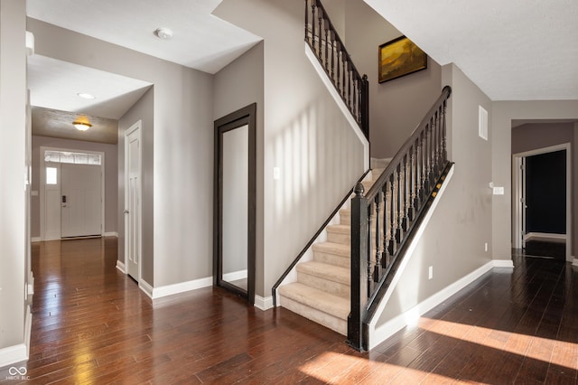 foyer with stairway, baseboards, and hardwood / wood-style flooring