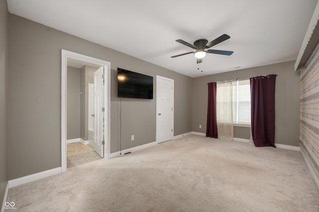 unfurnished room featuring a ceiling fan, light colored carpet, and baseboards