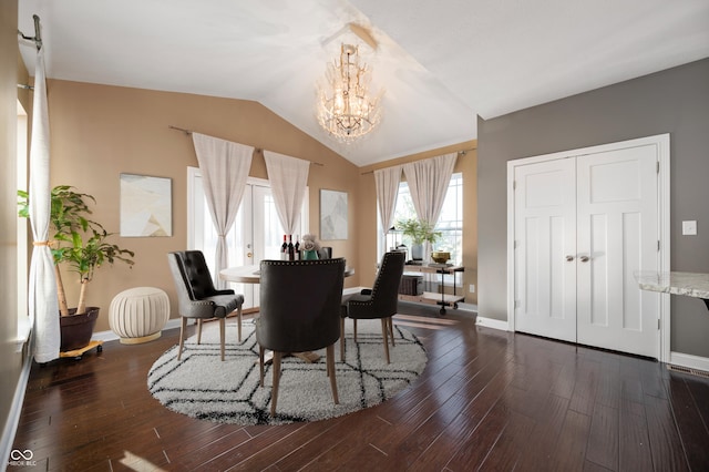 dining area featuring a chandelier, dark wood finished floors, baseboards, and lofted ceiling