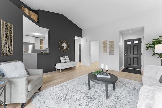 living room featuring light hardwood / wood-style flooring and vaulted ceiling