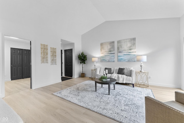 living room with vaulted ceiling and light hardwood / wood-style floors