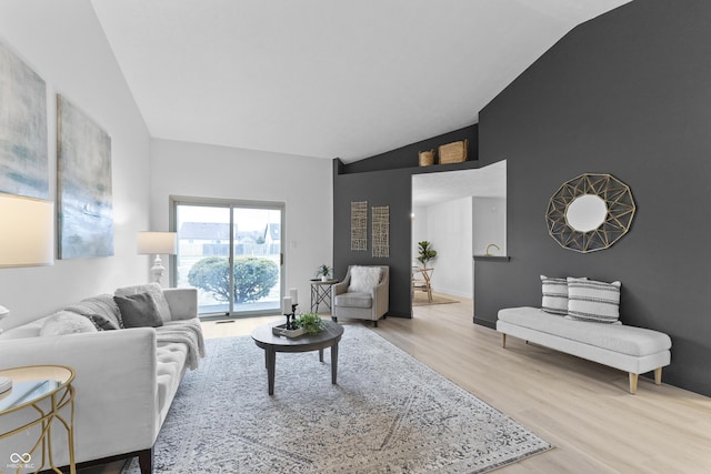 living room featuring lofted ceiling and light wood-type flooring