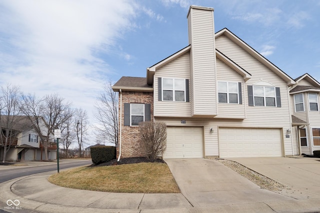 view of property featuring driveway, an attached garage, a chimney, and brick siding