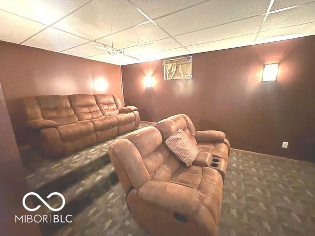 carpeted home theater with a paneled ceiling