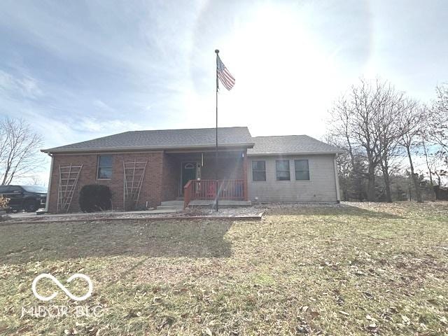 single story home featuring brick siding and a front yard