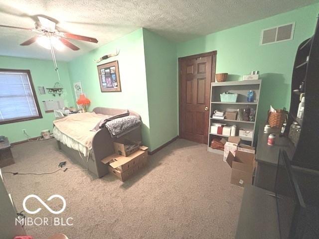 bedroom with a textured ceiling, carpet floors, ceiling fan, and visible vents