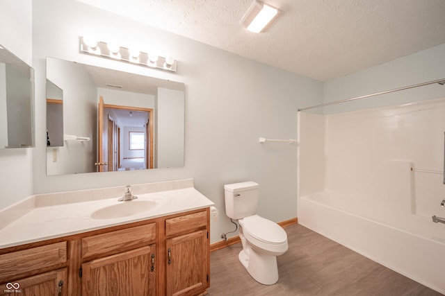 full bathroom featuring toilet, wood-type flooring, shower / bathing tub combination, a textured ceiling, and vanity