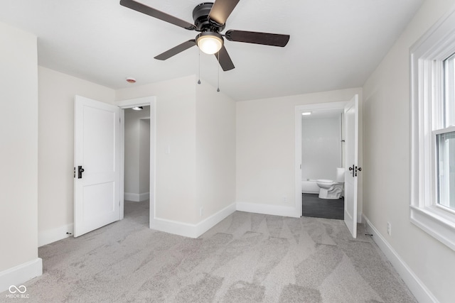 unfurnished bedroom with light carpet, ensuite bath, and ceiling fan