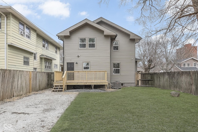 rear view of property with cooling unit, a wooden deck, and a lawn