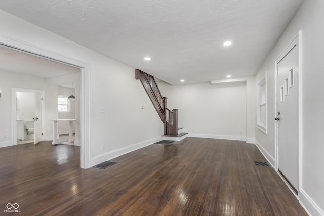 entrance foyer with dark hardwood / wood-style floors and a textured ceiling