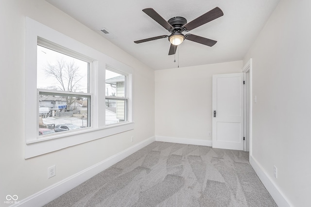 empty room featuring light colored carpet and ceiling fan