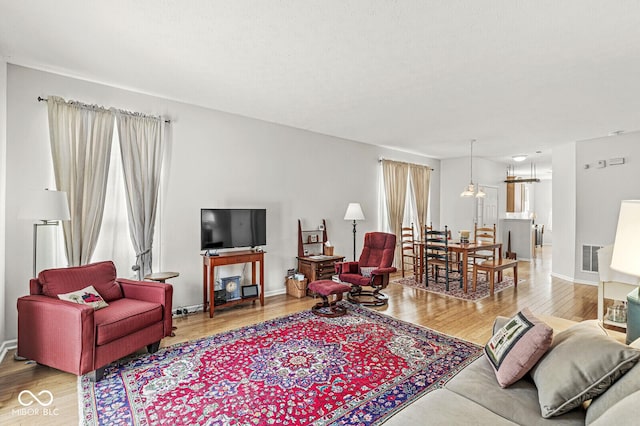 living area featuring wood finished floors, visible vents, and baseboards