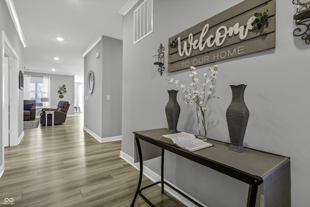 hallway featuring hardwood / wood-style flooring and ornamental molding