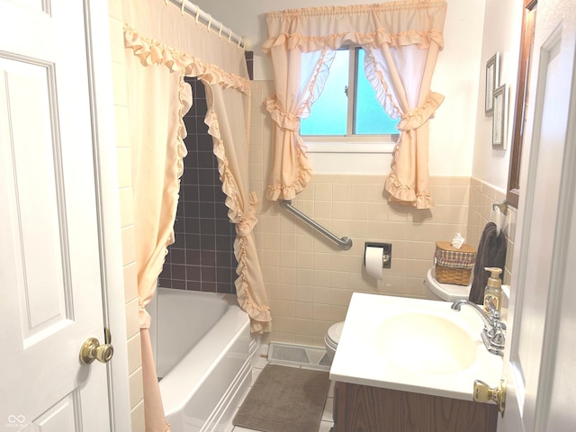 full bathroom with shower / tub combo with curtain, tile walls, tile patterned flooring, vanity, and toilet