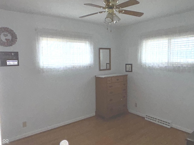 unfurnished room with hardwood / wood-style flooring, ceiling fan, and a wealth of natural light