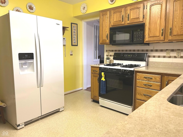 kitchen with decorative backsplash, range with gas cooktop, and white fridge with ice dispenser