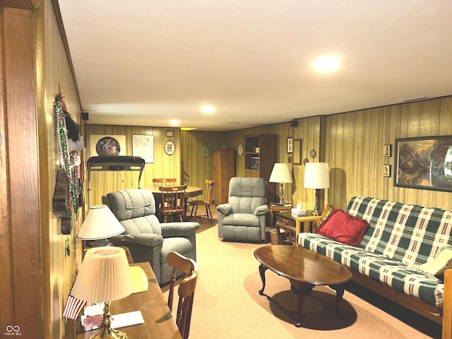 carpeted living room with wood walls