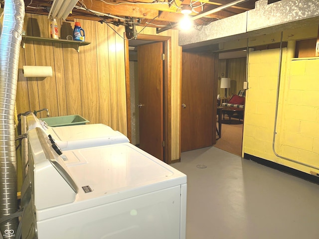 washroom with washer and dryer and wood walls