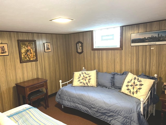 carpeted bedroom featuring wood walls