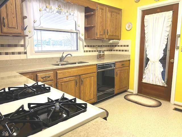 kitchen with tasteful backsplash, sink, range with gas cooktop, and dishwasher