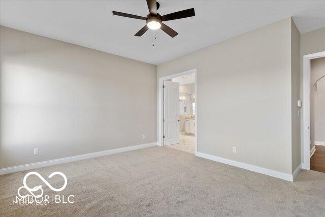 unfurnished bedroom with carpet floors, a ceiling fan, baseboards, and connected bathroom