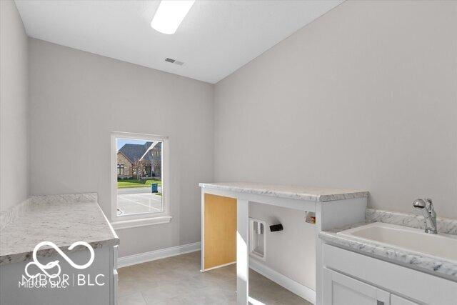 laundry area featuring a sink, visible vents, and baseboards