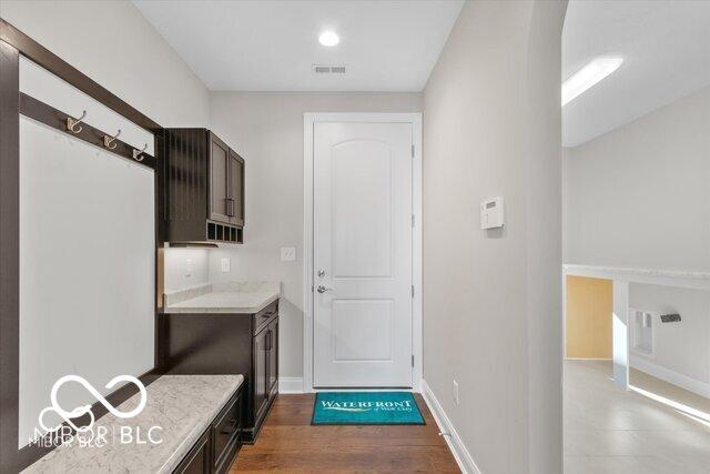 interior space featuring baseboards, visible vents, and dark wood-type flooring