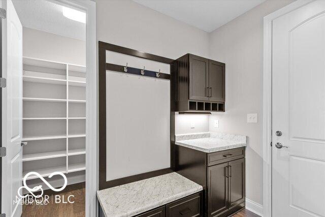 kitchen featuring dark brown cabinets, wood finished floors, and baseboards