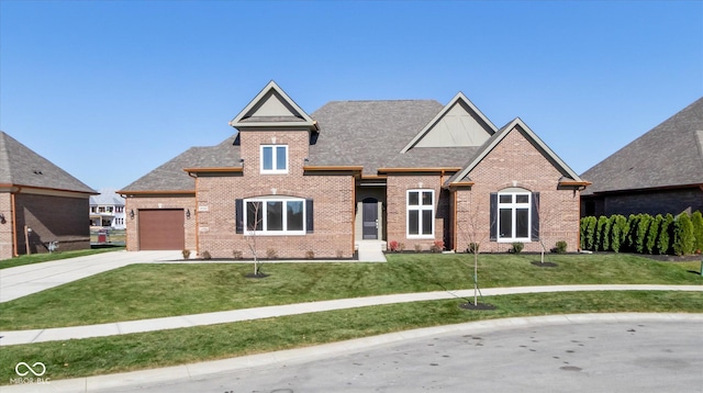 view of front of home with brick siding, a shingled roof, an attached garage, driveway, and a front lawn