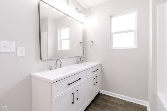 1305 W 23rd St, Indianapolis, IN 46208 - bathroom featuring double vanity, wood finished floors, and baseboards