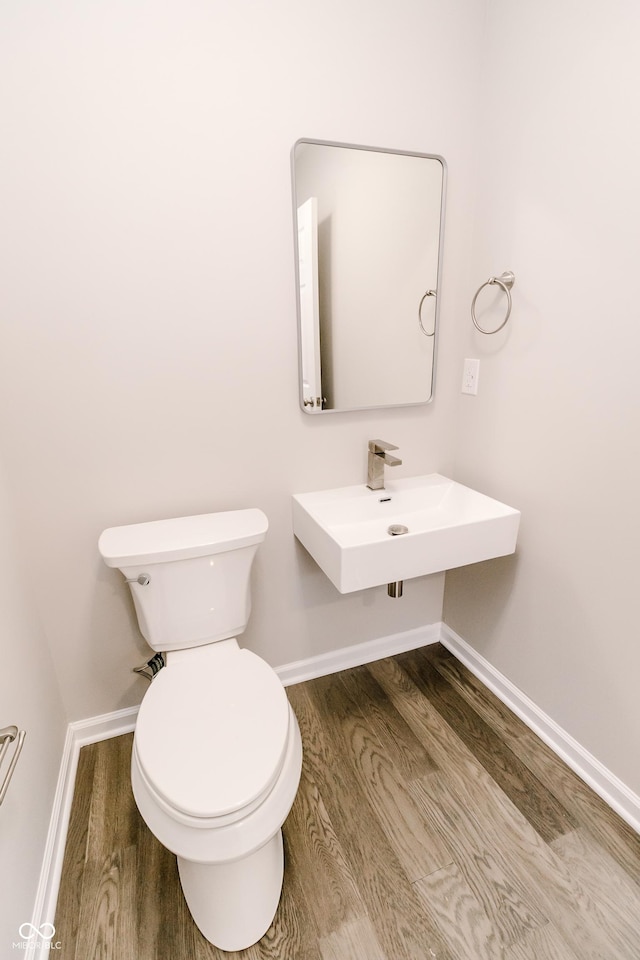 1305 W 23rd St, Indianapolis, IN 46208 - bathroom with wood finished floors, toilet, baseboards, and a sink