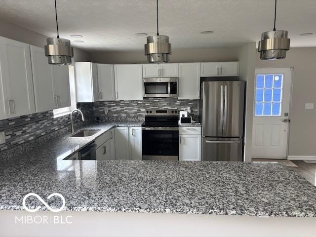 1305 W 23rd St, Indianapolis, IN 46208 - kitchen with stainless steel appliances, a sink, dark stone countertops, decorative backsplash, and white cabinetry